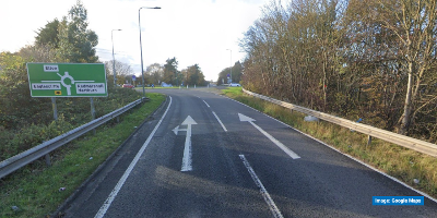 A Google Streetview image of the approach to the Elton Interchange roundabout, just off the A66. The two lane road has arrows in each lane and the roundabout can be seen in the background. A road sign on the left denotes the approaching roundabout.