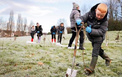 An image showing young children planting trees in the Borough