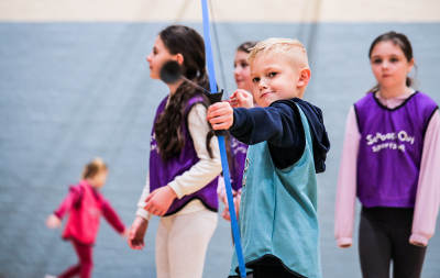 A young boy enjoying doing archery at a 'Holidays Are Fun' session 