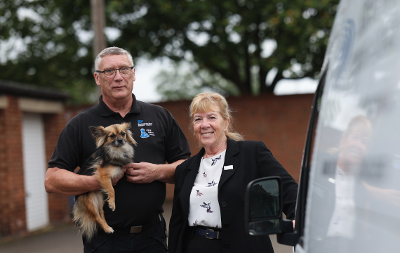 Councillor Norma Stephenson stood alongside a member of staff, who is holding a small dog