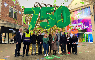 An image of staff from the Stockton-on-Tees Employment and Training Hub alongside some residents who have been helped into employment. Text above says "750".