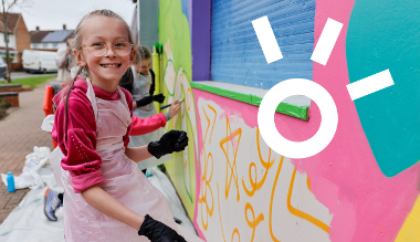 Children painting external wall with bright colours