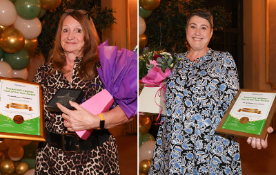 Two award winners holding award and flowers